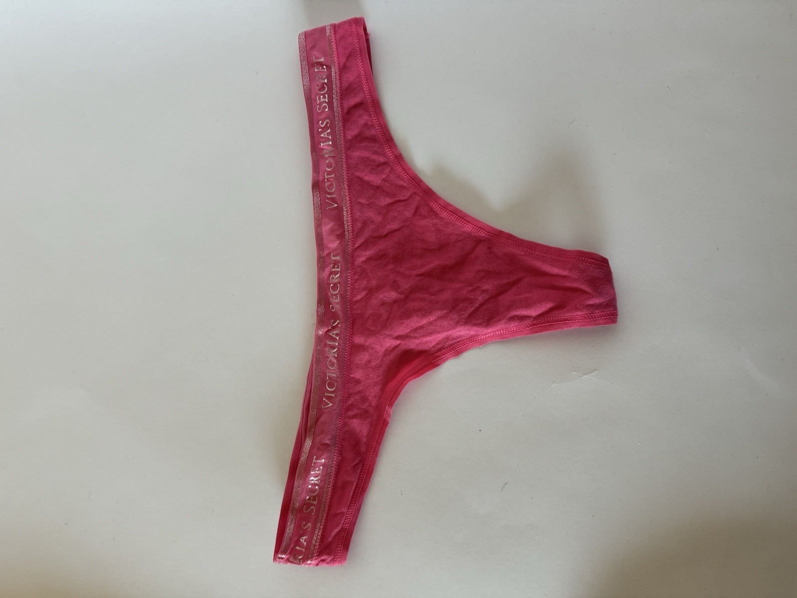 Victoria’s Secret pink thong panties with metallic logo waistband.